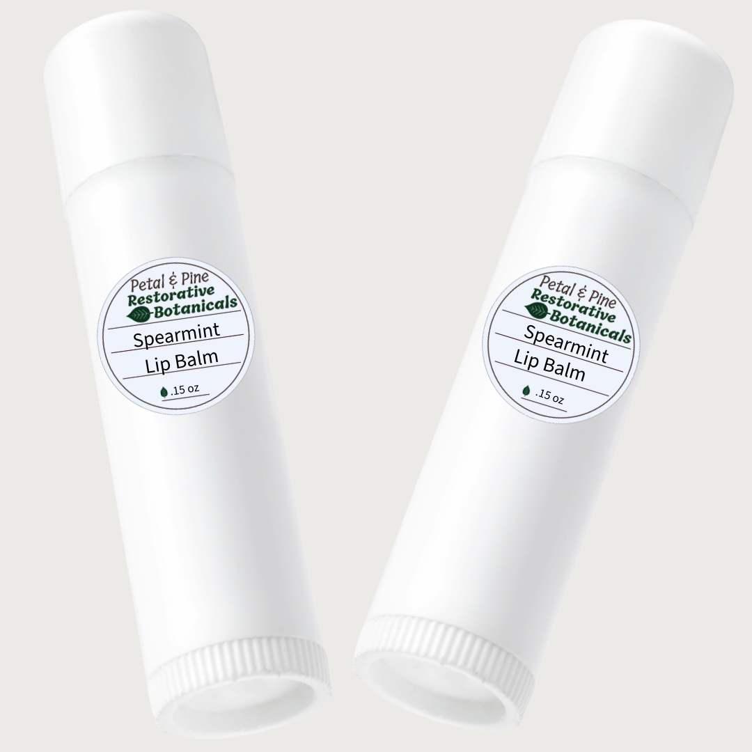 Two white lip balm tubes with Petal & Pine Spearmint labels on a light gray background